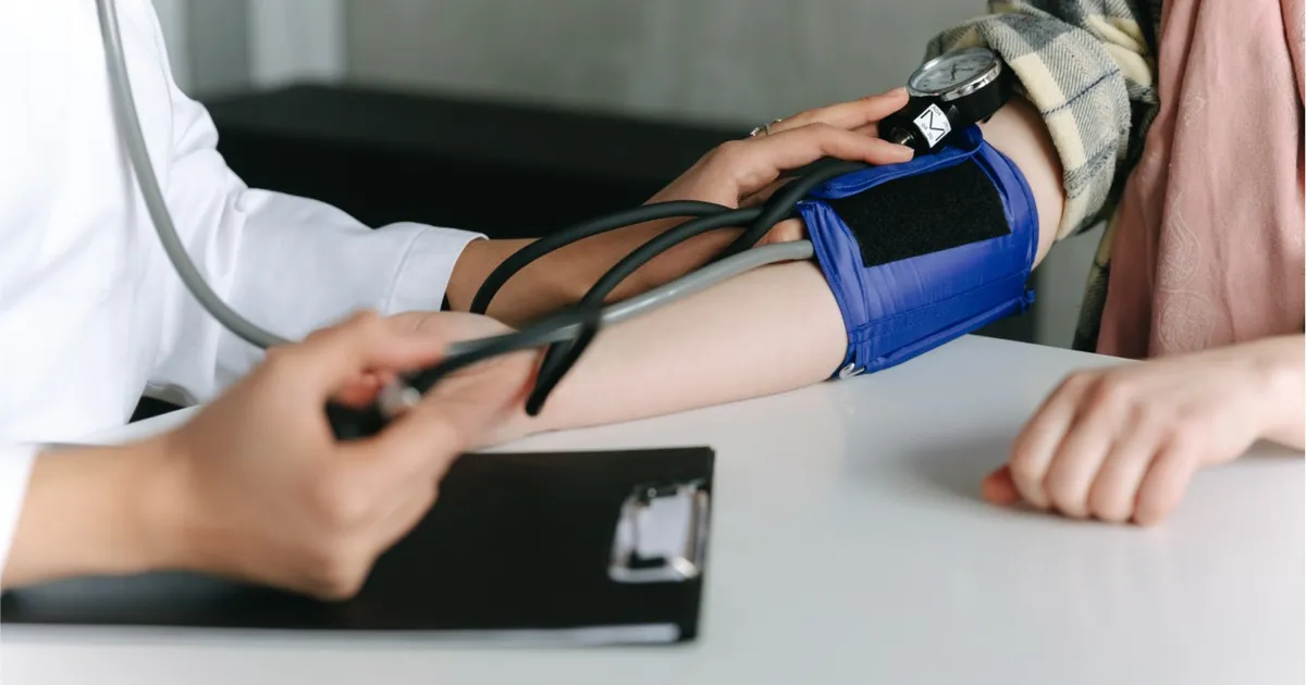 A clinician checking a patient's blood pressure during chronic care management