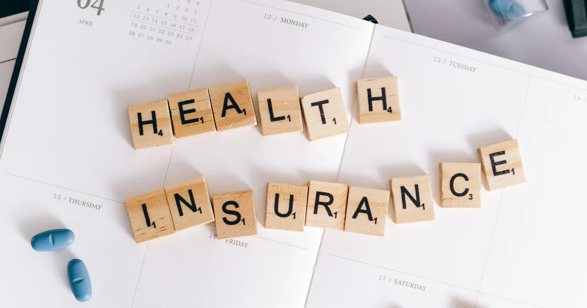 Wooden tiles spelling health insurance beside medication, illustrating Medi-Cal managed care coverage
