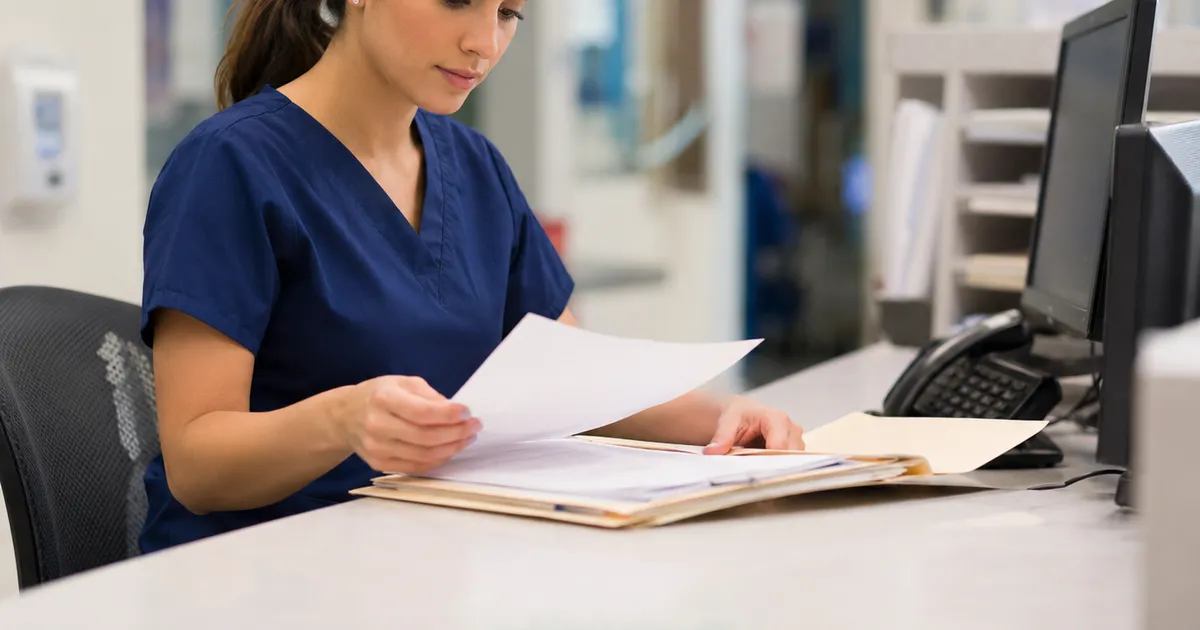 A medical biller reviewing primary care claims and denials at a desk